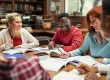Happy college students studying together