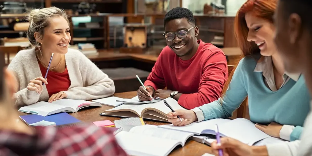 Happy college students studying together